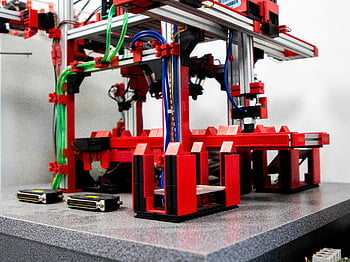 ロボット組立機、 赤と黒のマシン、 ワイヤー、 クローズアップビュー、 鮮やかな赤色のコンポーネント、 金属部品、 産業機器、 オートメーション技術、 機械装置、 製造機械、 ロボットアーム