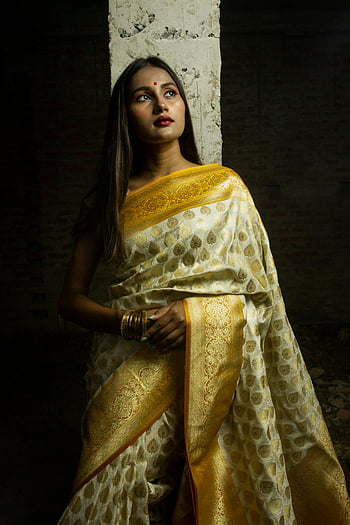 South Asian woman, yellow and gold sari, traditional dress, concrete pole, textured backdrop, portrait, South Asian fashion, cultural attire, elegant pose, traditional clothing, sari fashion