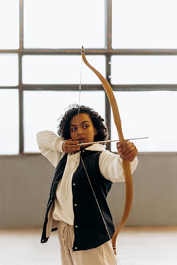 mujer joven, puntería, arco y flecha, concentración, adentro, habilidad, elegancia, tiro al arco, deporte, estilo de vida saludable, mujer atleta