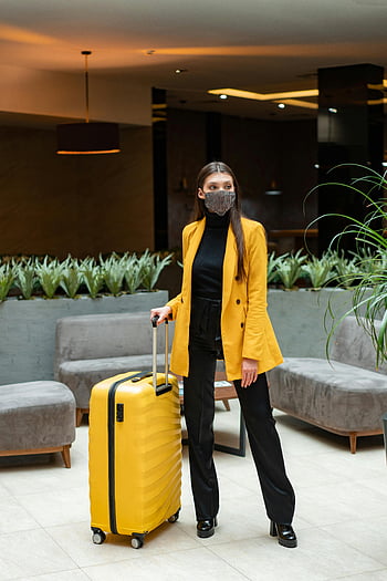 yellow coat, yellow suitcase, stylish woman, modern hotel lobby, face mask, travel fashion, hotel interior, luggage, contemporary design, travel style, woman traveler