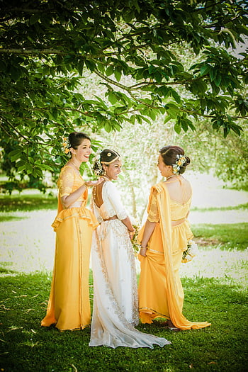 etnická nevěsta, družičky, zelený park, venkovní svatba, bílé šaty, žlutý oděv, radostný okamžik, svatební fotografie, kulturní svatba, šaty pro družičky, nevěsta a družičky