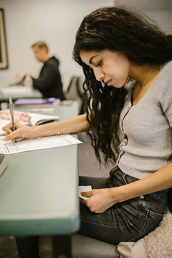 Schüler betrügen, Prüfungsbetrug, Betrug im Klassenzimmer, Schüler im Klassenzimmer, einen Test machen, Notizen ansehen, Akademische Unehrlichkeit, Testbetrug, Fehlverhalten von Studenten, Fehlverhalten bei Prüfungen, Fehlverhalten im Klassenzimmer