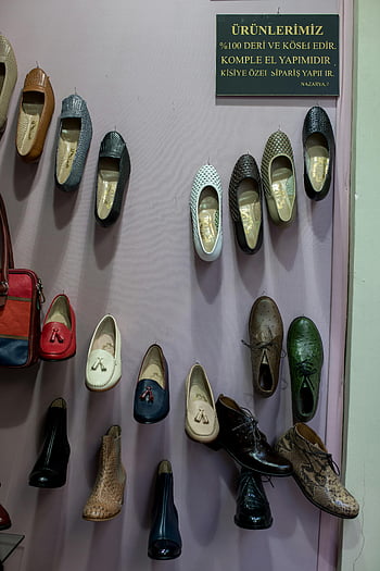 handmade leather shoes, colorful shoes, wall display, boutique store, leather footwear, handmade shoes, wall-mounted shoes, leather goods, boutique interior, shoe collection, leather manufacturing