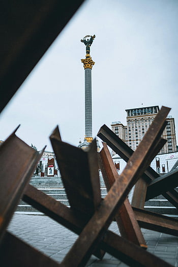 metal barricades, Independence Square, Kyiv, Independence Monument, resilience, conflict, protective structure, Ukraine, cityscape, urban scene, monument