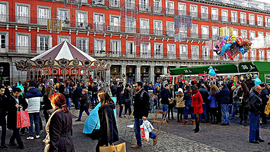 Madrid, Spain, Plaza Mayor, December 26, 2015, carousel, crowd, people, red building, festive, balloons