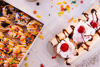 banana split, różne pączki, Miłośnicy deserów, żywa mieszanka, Biała taca, pokrojone ciasta, polewa wiśniowa, Kolorowe posypki, lody, mżawka czekoladowa, słodkie smakołyki