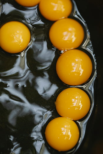 Faire frire des œufs, petits oeufs, poêle à frire, jaunes d'œufs crus, casserole noire, vue rapprochée, oeufs frais, la cuisson des oeufs, jaunes brillants, cuisson parfaite, préparation aux œufs