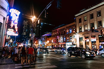 night cityscape, illuminated street, busy downtown, neon lights, nightlife scene, urban nightlife, city traffic, people walking, night traffic, vibrant city, night urban scene