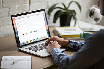 Macbook Pro, Heimarbeit, modernes Büro, Mann arbeitet, Laptop, Schreibtisch, Kaffee, Arbeitsplatz, Produktivität, Bücher, Pflanzen