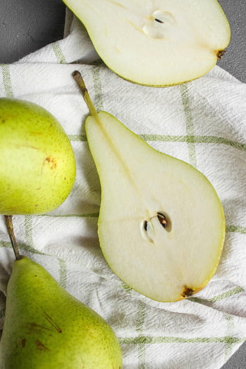 green pears, tablecloth, fresh pears, organic snack, top view, white cloth, healthy snack, sliced pears, pear seeds, green cloth, pear halves
