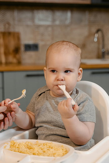 baby eating, close-up baby, high chair, home kitchen, cute baby, enjoying meal, precious moment, baby food, baby spoon, baby meal, baby in high chair