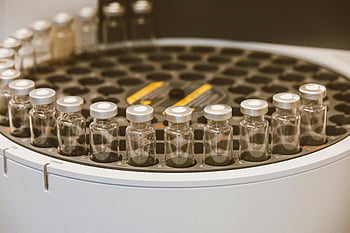 glass vials, round container, lab setting, scientific research, clear glass, vials array, laboratory equipment, research visuals, medical supplies, scientific tools, vial storage