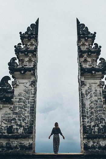 woman standing, split gateway, Candi Bentar, Bali, Indonesia, traveler, iconic, architecture, travel destination, cultural landmark, ancient structure