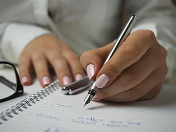 vrouw schrijven, wit shirt met lange mouwen, pen vasthouden, Schrijven op papier, notitieboekje, Vulpen, roze nagels, detailopname, handen, bril, bureau