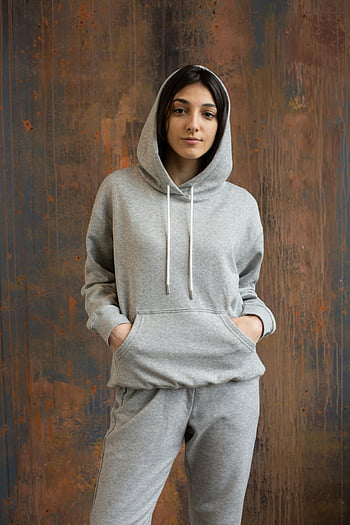 giovane donna, felpa grigia con cappuccio, muro rustico, abbigliamento sportivo, donna etnica, abbigliamento sportivo grigio, muro di legno, Abbigliamento casual, in piedi posa, fotografia di moda, Immagine dello stile di vita