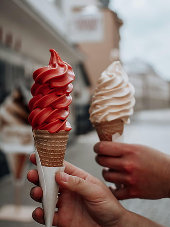 soft served ice cream, colorful ice cream cones, outdoor setting, hands holding ice cream, ice cream cones, detailed view, soft serve, ice cream, outdoor ice cream, people holding ice cream, ice cream swirls