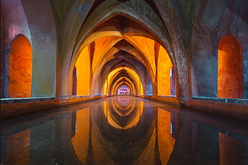 Gothic arches, water reflection, vibrant colors, mesmerizing effect, orange and gray, tunnel painting, architectural beauty, indoor archway, symmetrical reflection, artistic composition, serene atmosphere