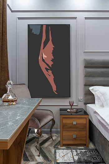 bedroom interior, contemporary art painting, elegant furniture, glass decanter, stylish bedroom, modern decor, nightstand, desk chair, wall art, marble countertop, wooden flooring