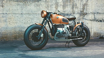 BMW motorcycle, orange and black, cafe racer, vintage style, industrial backdrop, concrete wall, classic motorcycle, parked motorcycle, retro design, urban setting, motorbike photography