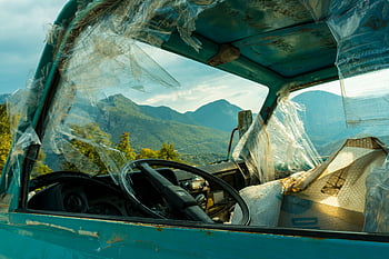 black vehicle steering wheel, old rusty truck, broken windows, mountain landscape, decay, abandoned vehicle, interior view, steering wheel close-up, outdoor scene, nature backdrop, vehicle decay
