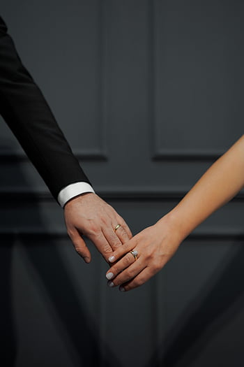 bride and groom, holding hands, wedding couple, close-up, rings, dark background, wedding rings, engagement ring, wedding photography, romantic moment, couple in love