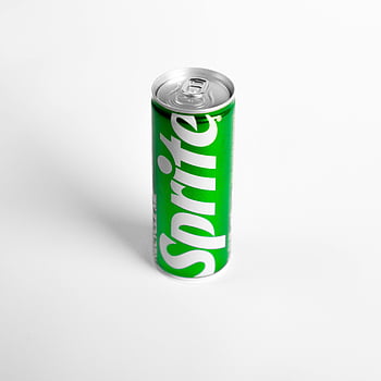 Sprite může, zelená plechovka sody, bílé pozadí, minimalistický styl, zářivá zelená, soda může, bílý povrch, nápadný kontrast, minimalistický design, zelená plechovka