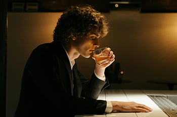검은 옷을 입은 남자, 맥주를 마시다, 우아한 바, 부드러운 주변 조명, 음료를 즐기십시오, 남자 정장을 입고있다., 주변 조명, 우아한 환경, 바 장면, 음주 장면, 맥주를 마시는 사람