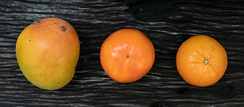 fresh ripe orange, mandarin, persimmon, mango, rustic wooden surface, vibrant fruits, top view, fresh produce, fruit composition, orange fruit, persimmon fruit