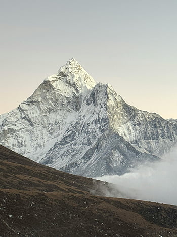 Mount Everest, Himalayas, snow-capped peaks, misty valleys, sunrise, breathtaking view, mountain landscape, high altitude, natural beauty, adventure travel, scenic mountain