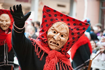 cultural festival, traditional costumes, masked performers, colorful parade, brown mask, red polka dots, celebration, cultural event, festival celebration, traditional celebration, cultural parade