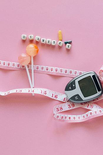 diabetes, glucometer, tape measure, pills, lollipops, pink surface, close-up shot, health, medical, lifestyle, measurement