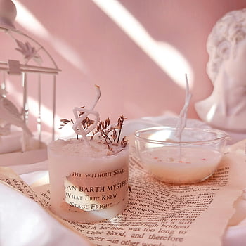 pink scented candles, close-up shot, aromatic candles, vintage book, soft pink background, serene arrangement, candle decor, candle photography, candle aesthetic, candle ambiance, candle lifestyle