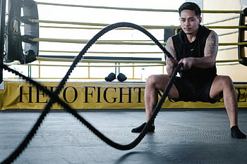 Latin American man, battle rope workout, gym setting, muscular man, intense exercise, strength training, endurance workout, fitness, workout, battle ropes, gym