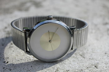 orologio d'argento, orologio analogico, orologio minimalista, orologio da polso argentato, superficie di cemento, Eleganza senza tempo, orologio da vicino, orologio color argento, orologio elegante, design minimalista, Close-up orologio da polso
