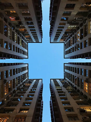 block of flats, symmetrical view, low angle view, high-rise buildings, architecture photography, clear blue sky, urban architecture, architectural design, modern buildings, cityscape photography, symmetrical composition