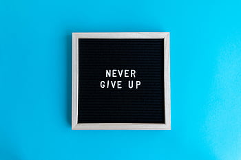 motivational quote, letter board, never give up, vibrant blue background, black letter board, inspirational message, framed quote, motivational frame, blue background, letterboard quote, motivational letterboard