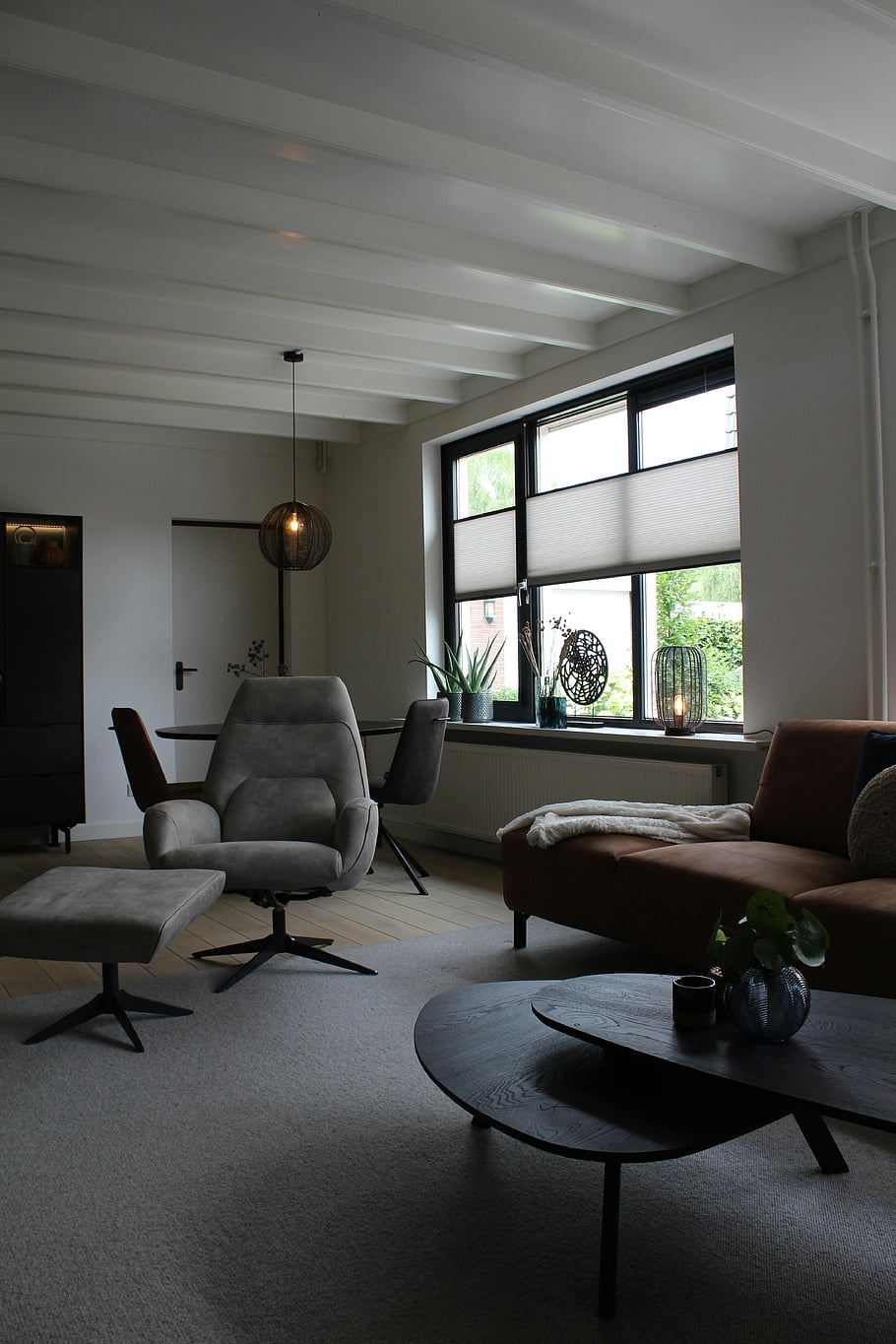 útulný obývací pokoj, moderní nábytek, přirozené světlo, Elegantní výzdoba, Stylový interiér, moderní design, pohodlné sezení, pokojové rostliny, velká okna, neutrální barvy, Útulná atmosféra
