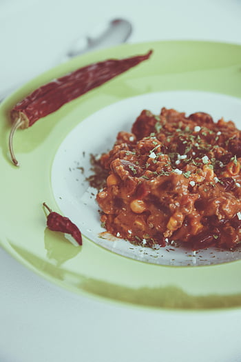 chili dish, red chili peppers, green plate, comfort food, flavorful, spicy, homemade, meal, food photography, traditional, vegetarian