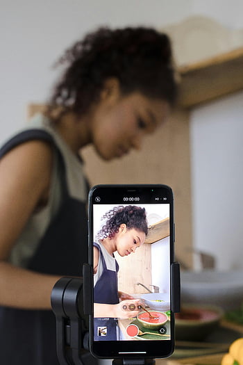 žena streamuje, připravování jídla, Video vaření, nahrávání smartphone, příprava jídla, kuchyňské scény, potravin blogger, kulinářský obsah, Živý přenos, Výukový program vaření, smartphone fotoaparát