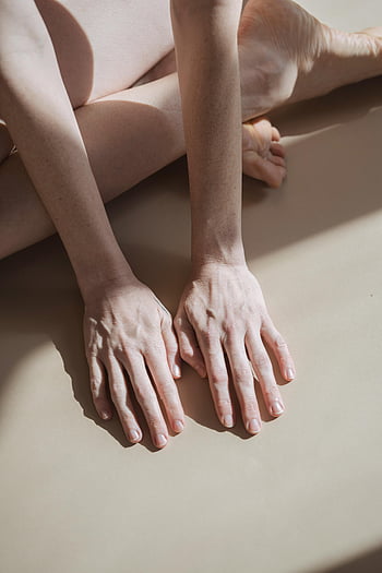 minimalist photo, barefoot person, natural light, calmness, hands and feet, sunlight, white floor, cropped image, serene atmosphere, soft shadows, human body parts