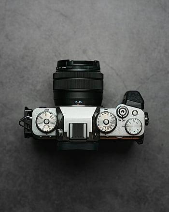 camera top view, detailed camera photo, camera controls, gray backdrop, camera lens, camera settings, top view photography, camera dials, camera equipment, camera features, camera design