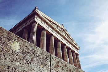 ancient Greek temple, Doric columns, blue sky, historic landmark, classical architecture, cultural heritage, majestic monument, outdoor structure, timeless travel, sunlit ruins, symmetry art