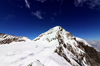 snow-covered peaks, clear blue sky, Interlaken, Switzerland, mountain panorama, snow-covered mountain, winter landscape, alpine scenery, mountain view, snow-capped mountains, breathtaking view