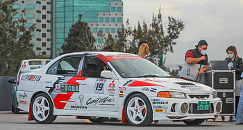 Weißer und roter Mitsubishi Evo, modifiziertes Mitsubishi-Rallyeauto, im Freien geparkt, Menschen in der Nähe, Rallyefahrzeug, Mitsubishi Evo, Parkplätze im Freien, Autoliebhaber, Rennauto, modifiziertes Auto, Rallye -Veranstaltung