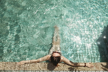 woman relaxing, pool, sunlit outdoor pool, enjoying swim, relaxing swim, outdoor pool, woman at pool, poolside relaxation, summer relaxation, water relaxation, poolside scene