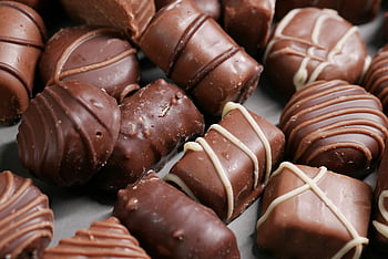 brown chocolates, close-up shot, assorted chocolates, gourmet chocolates, delicious chocolates, beautifully arranged, chocolate treats, chocolate candies, chocolate confections, chocolate desserts, chocolate sweets