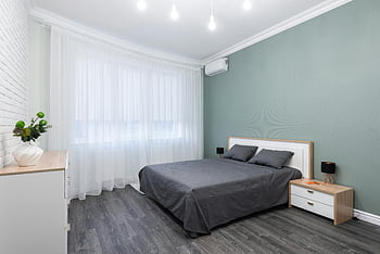 moderní ložnice, šedé akcenty, měkké osvětlení, minimalistický design, lesklé lampy, klidný interiér, Současný nábytek, bílé záclony, dřevěná podlaha, noční stolek, lůžko
