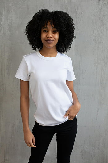 donna di colore, allegro, ritratto in studio, donna fiduciosa, maglietta bianca, sfondo grigio, positività, capelli afro, fotografia in studio, Stile casual, empowerment femminile
