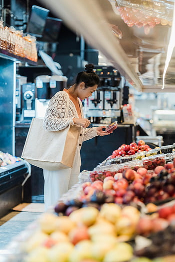 Asian woman, buying groceries, fresh fruits, vibrant supermarket, indoor setting, supermarket shopping, grocery shopping, fresh produce, market setting, fruit selection, supermarket environment
