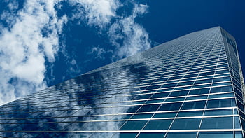 worm's eye-view, high-rise building, low-angle view, modern skyscraper, reflective glass windows, blue sky, architecture photography, urban landscape, cityscape, building exterior, glass facade